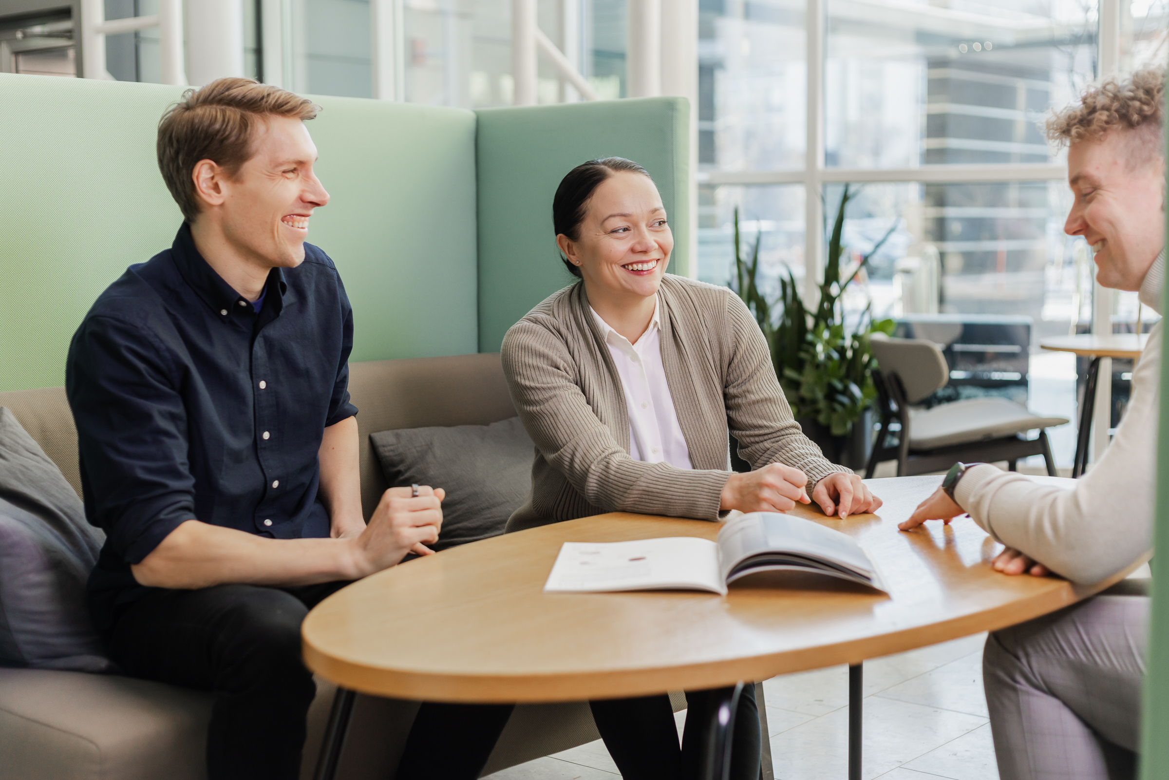 Vieser staff members seated around a table in a modern office, engaged in a collaborative discussion.